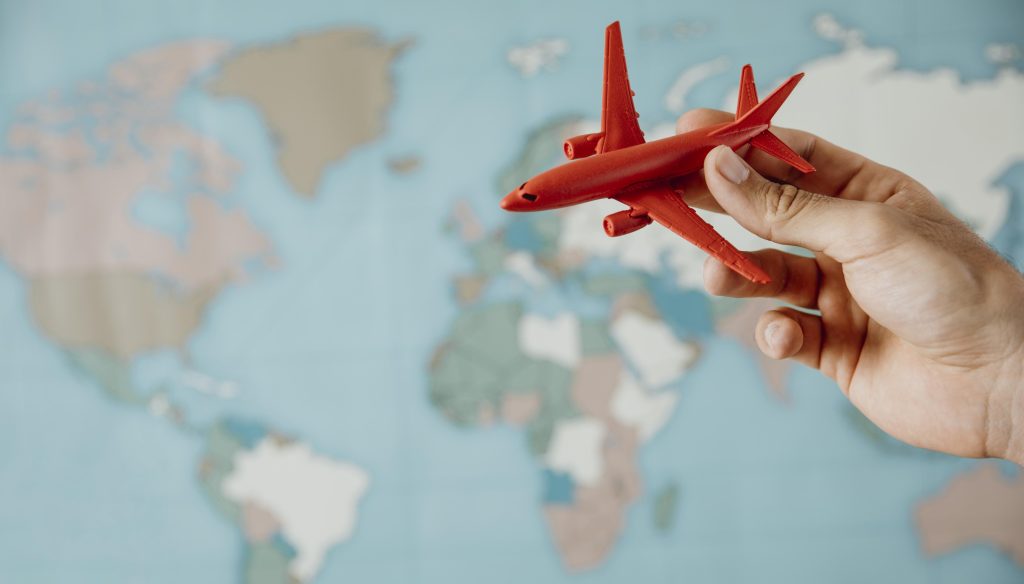 side view person holding airplane figurine map